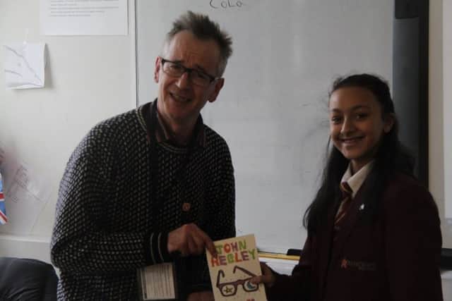 John Hegley presenting a signed copy of his poetry book to one of the poetry competition winners, Olivia Chaudhari