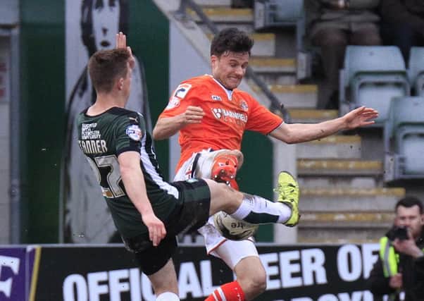 Jonathan Smith puts a full-bloodied challenge in against Plymouth