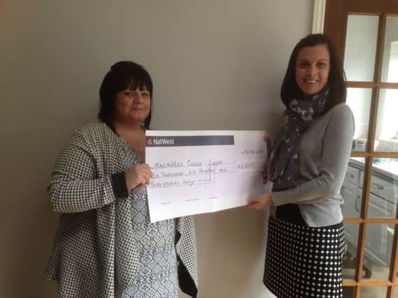 Laura Ross presenting the cheque to Jessica Wilson of Macmillan