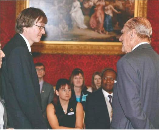 Stopsley teacher David Bond receives a long service award from the Duke of Edinburgh