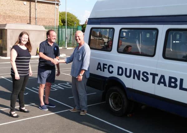 Music 24's Teela Hughes and Graeme Davis with AFC chairman Simon Bullard and the bus the club donated