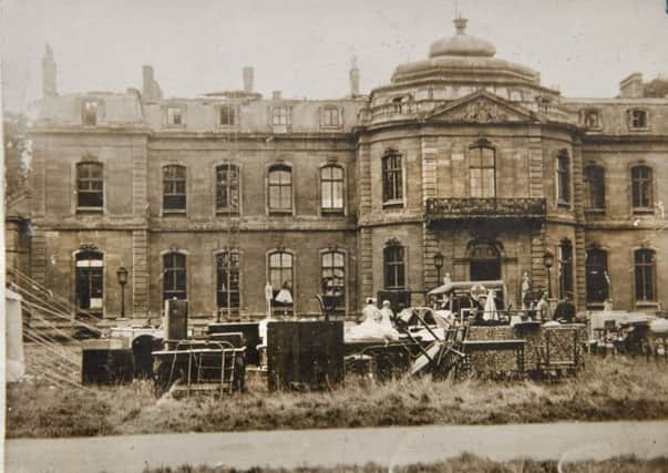 The north front of Wrest House after the fire with rescued furniture in the foreground. From a private collection.