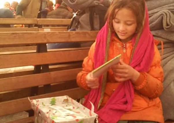 A displaced refugee child from Macedonia stares in wonder at her shoebox from Operation Christmas Child