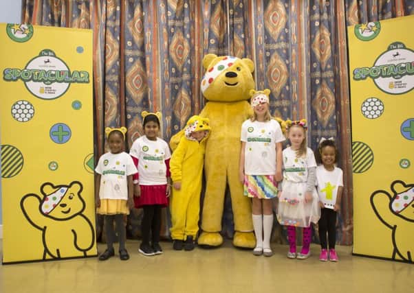 The delighted pupils pose with the nation's favourite bandaged bear