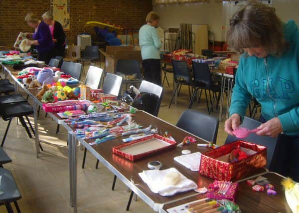 Members of  St Augustine's Limbury Mother's Union hard at work packing gift-filled shoeboxes for  Operation Christmas Child