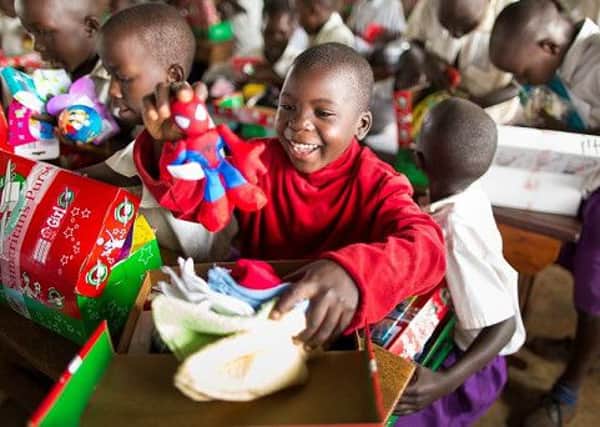 Children in Uganda show their delight as they open shoeboxes filled with toys contributed by Operation Christmas Child EMN-151026-143444001