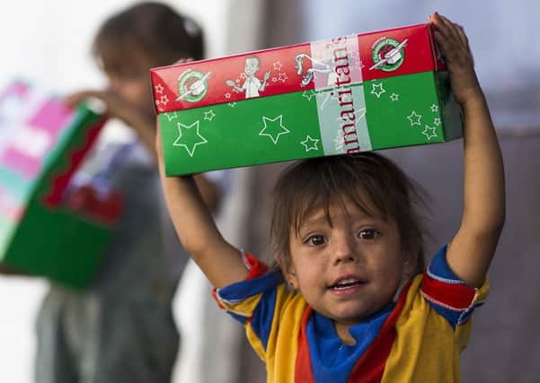 A child receiving a Christmas present donated through the Operation Christmas Child appeal PNL-150122-102715001