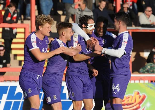 Danny Hylton is mobbed after scoring at Exeter