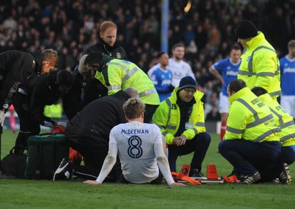 Cameron McGeehan receives treatment after breaking his leg at Portsmouth