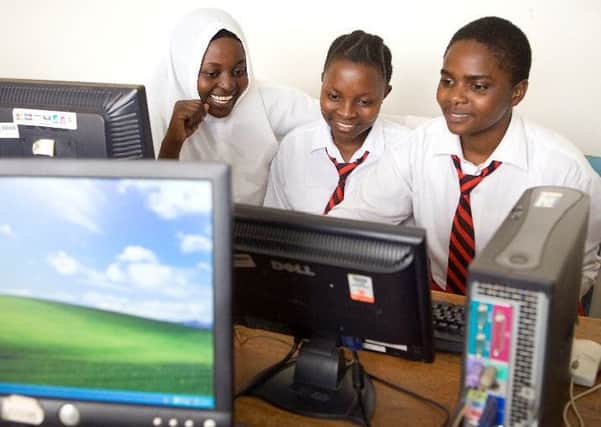 Delighted African school children working on computers that have been refurbished and re-used