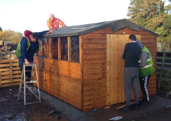 Vauxhall volunteers help put up a shed at Stockwood allotments for young people's charity YAWN