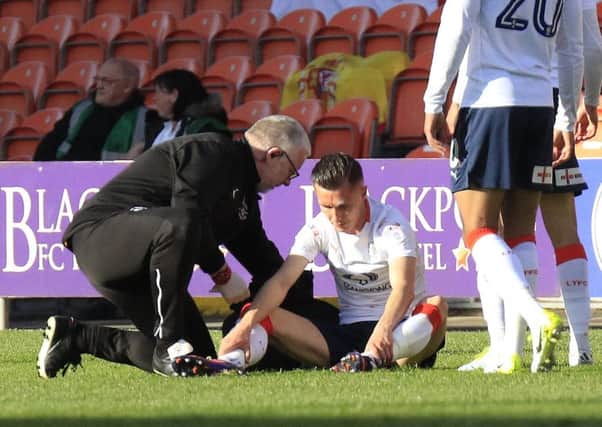 Dan Potts receives treatment for his injury at Blackpool