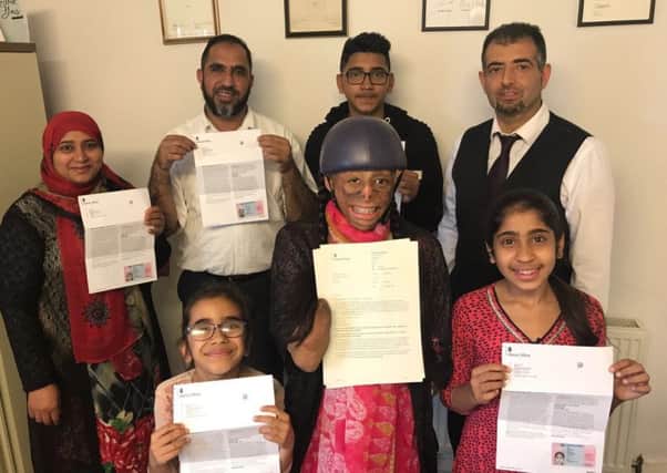 The Arif family receive their permits. Back row from left: mum Tahira, dad Mohammed, brother Shakaib and lawyer Khuram Liaquat. Front tow from left sister Monoor, Shamiam and sister Shamita